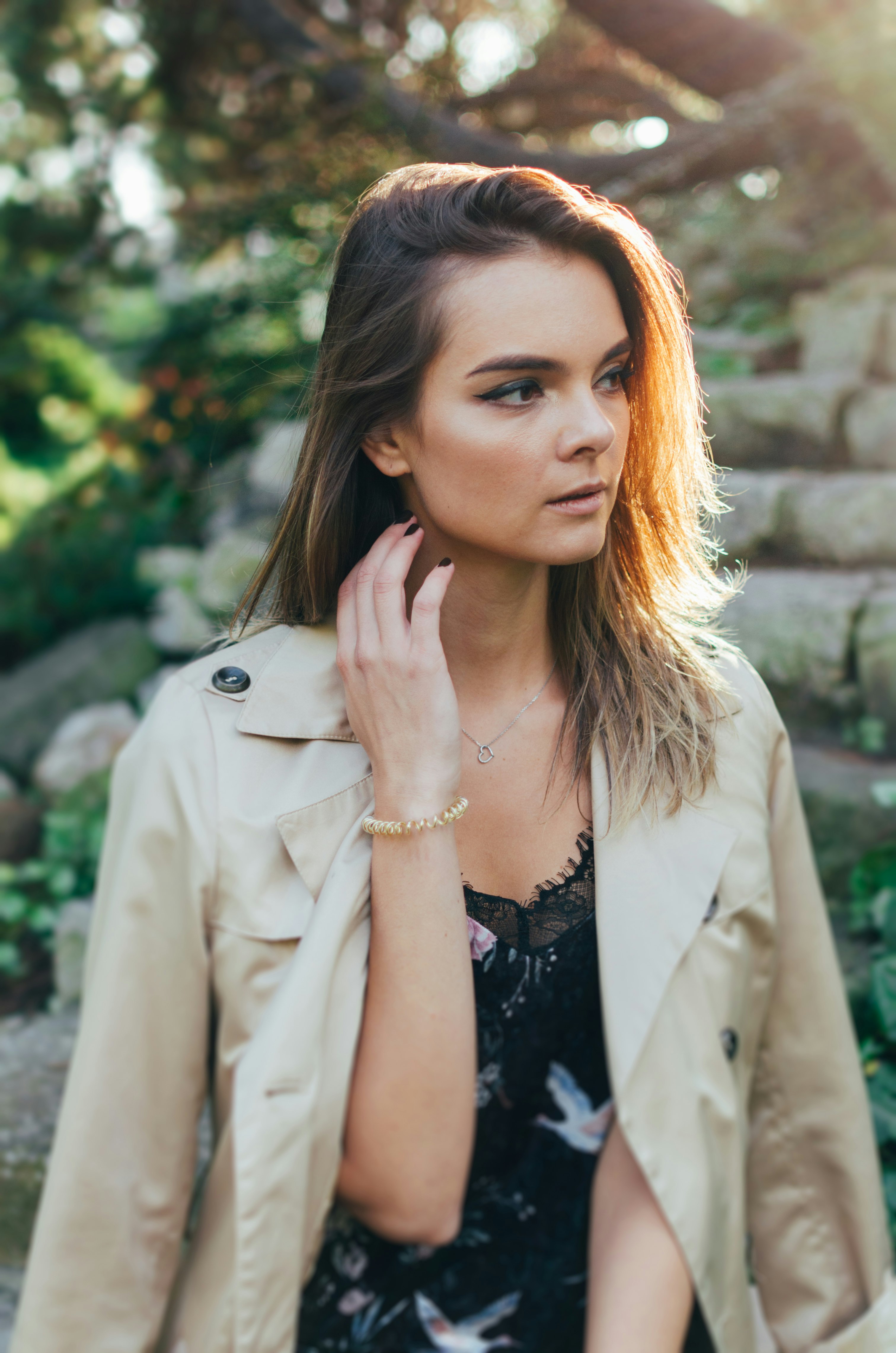 woman in beige coat and black floral shirt